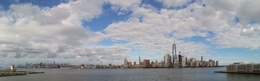 Skyscrapers in city against cloudy sky