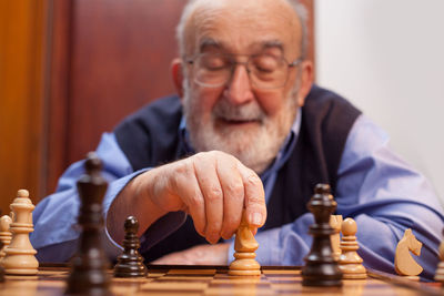 Senior man playing chess at home