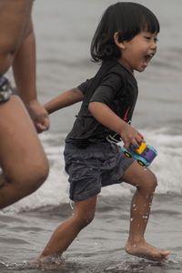 Side view of boy playing at beach
