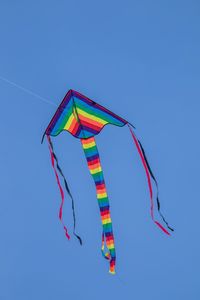 Low angle view of kite against clear blue sky