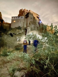 People walking on historic building against sky