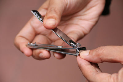 Cropped hands cutting nail