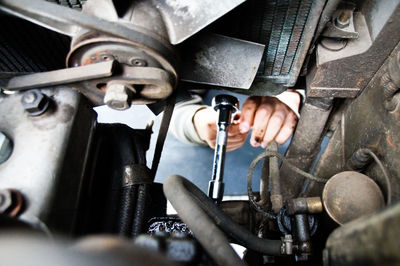 Close-up of mechanic working on car engine