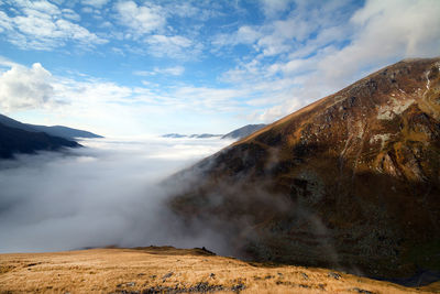 Scenic view of clouds and mountains against sky