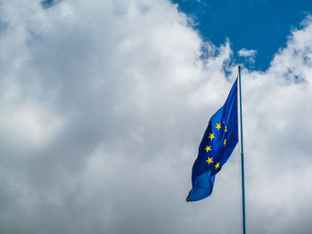 Low angle view of flag against cloudy sky