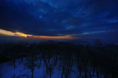 Scenic view of snow covered land against sky at sunset