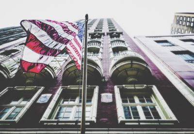 Low angle view of flag against buildings in city