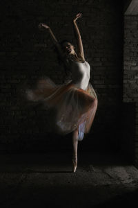 Full length of ballet dancer in abandoned building