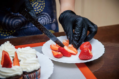 Midsection of person preparing food on cutting board