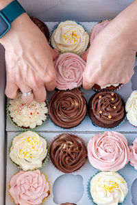 Home baked cupcakes beautifully decorated with buttercream on top placed delivery box.