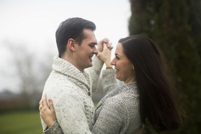 Young couple outside dancing together in a garden