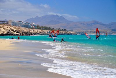 Scenic view of windsurfers on beach