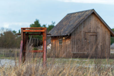 Old abandoned house on field against sky