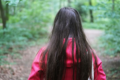 Rear view of woman standing in forest