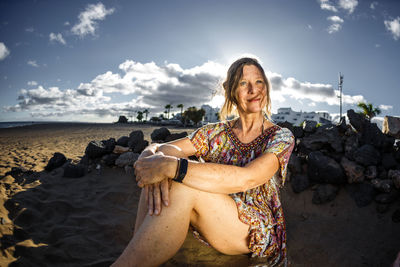 Young woman sitting on rock at beach