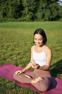 Portrait of young woman sitting on field