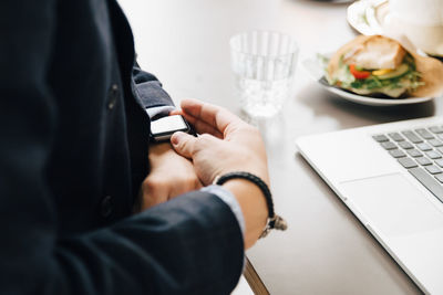 Midsection of man using laptop on table