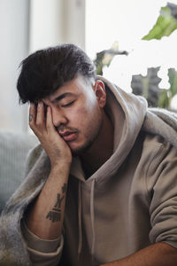 Ill man on sofa with hand covering face