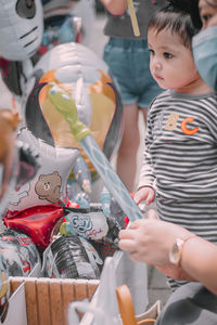 Girl looking at balloons in market