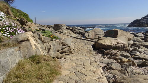 Rock formation on beach against sky