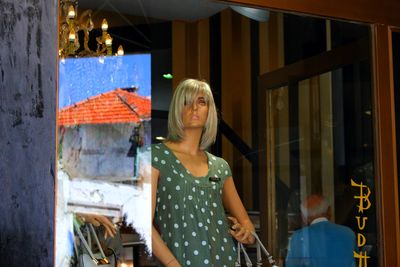 Young woman standing against building in city