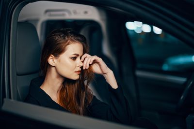 Portrait of young woman sitting in car