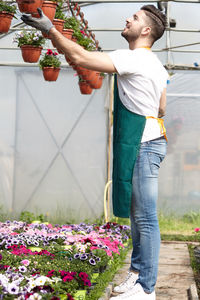 Full length of man standing by flower pot