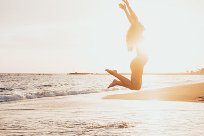 Silhouette woman doing yoga at beach