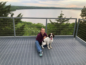 High angle view of dog and girl on overlook at sunset