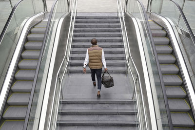 Rear view of man climbing steps at subway station