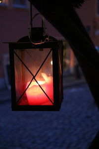 Close-up of illuminated lamp against sky during sunset