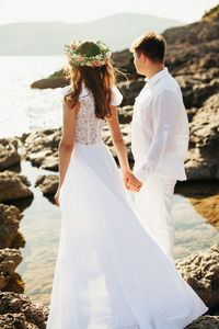 Rear view of couple standing at beach