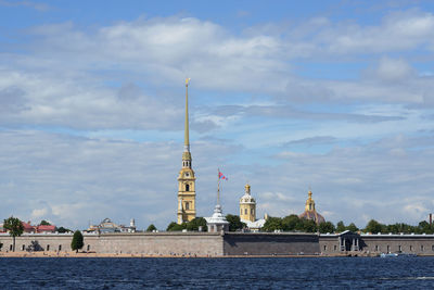 View of building by river against sky in city