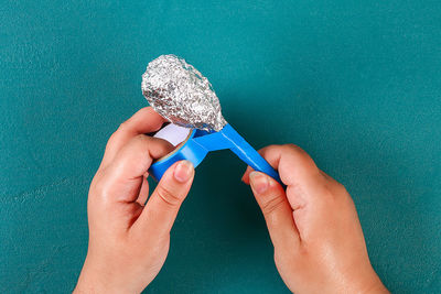 Close-up of woman hand against blue background