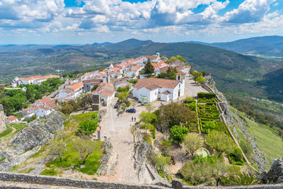 Scenic view of residential building and mountains against sky