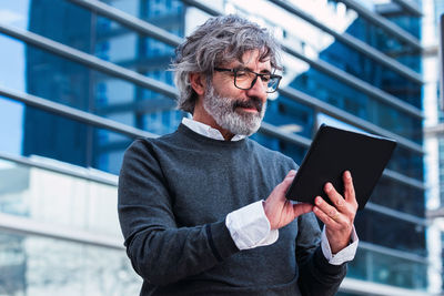 Senior businessman with eyeglasses working on digital tablet