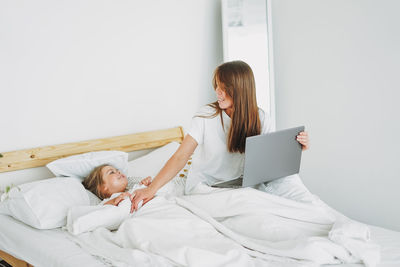 Woman lying down on bed at home