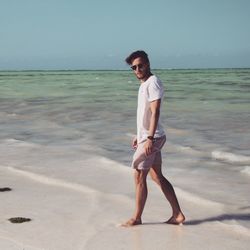 Portrait of young man standing at beach