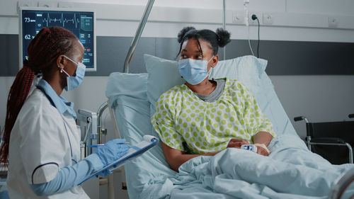 Doctor discussing with patient in ward at hospital