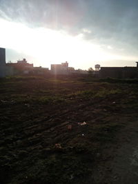 Built structure on field against cloudy sky