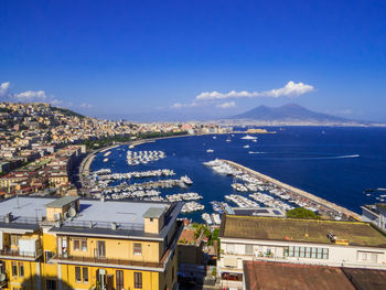 High angle view of city by sea against sky