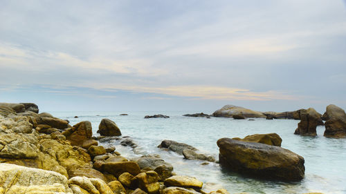 Rocks on sea shore against sky