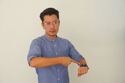 Portrait of young man standing against white background