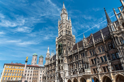 The townhall at the marienplatz in munich with the towers of the frauenkirche in the back