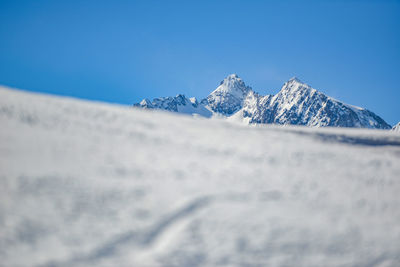 Scenic view of snowcapped mountains against clear blue sky