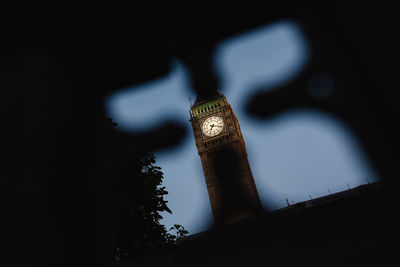 Low angle view of clock tower against sky at night