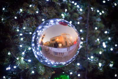 Low angle view of illuminated christmas tree on glass