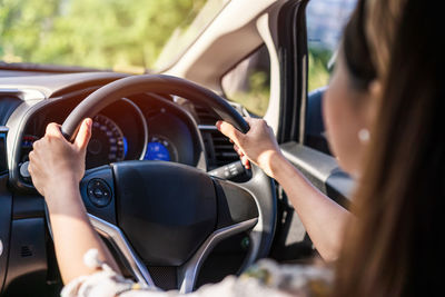 Midsection of woman driving car