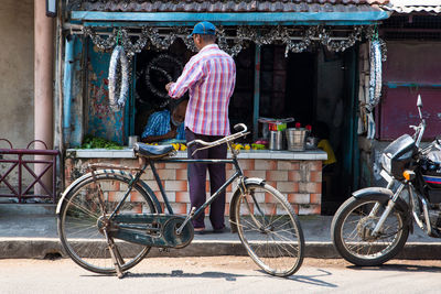 Man with bicycle standing against graffiti