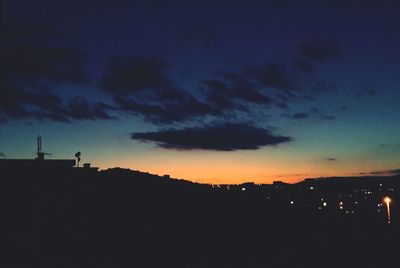 View of illuminated built structures at sunset